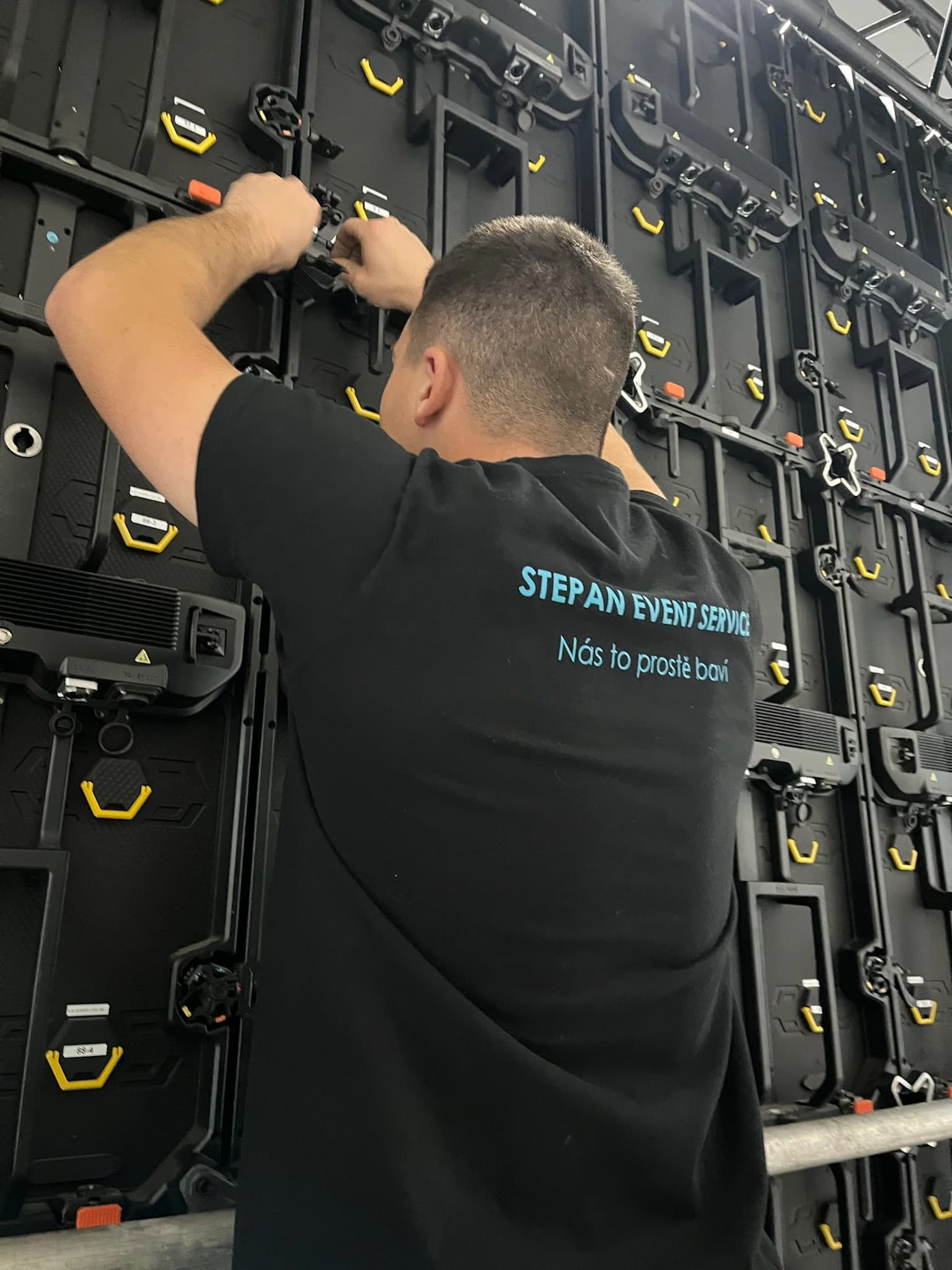 Technik Stepan Event Service montující LED panely na konstrukci